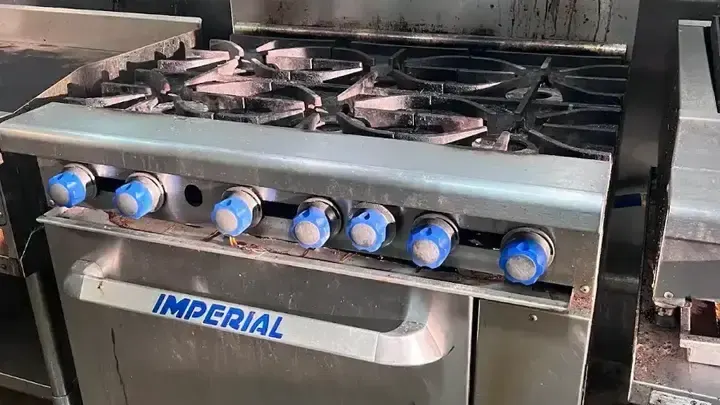 An Imperial range with six open burners and an oven below.