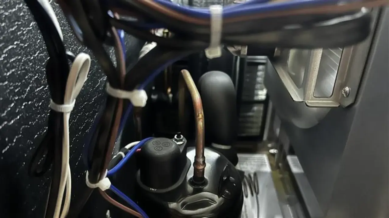Tuberías de cobre, cableado y zona del compresor dentro de una unidad frigorífica.